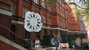 Tower clocks manufactured for monument tower with analog clock control being hoisted for installation
