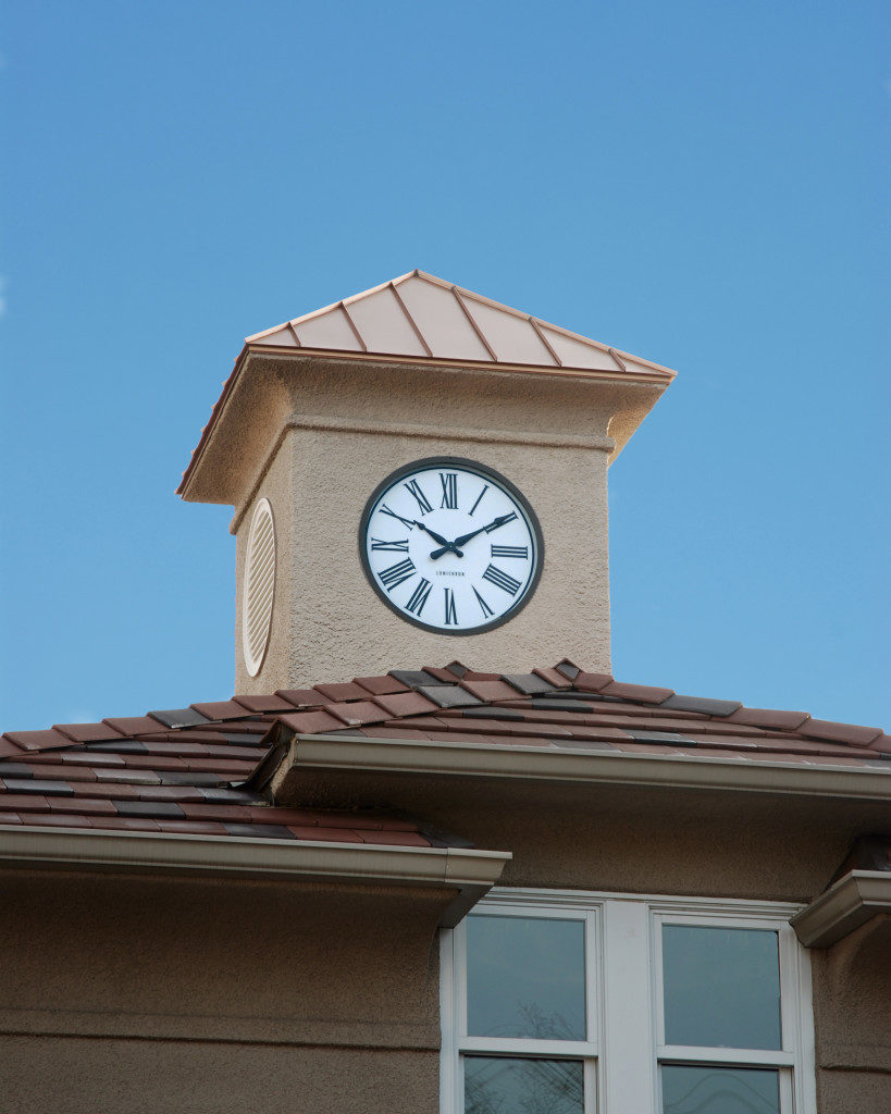 Clock tower on top of residence with roman numeral hour markers on face of clock