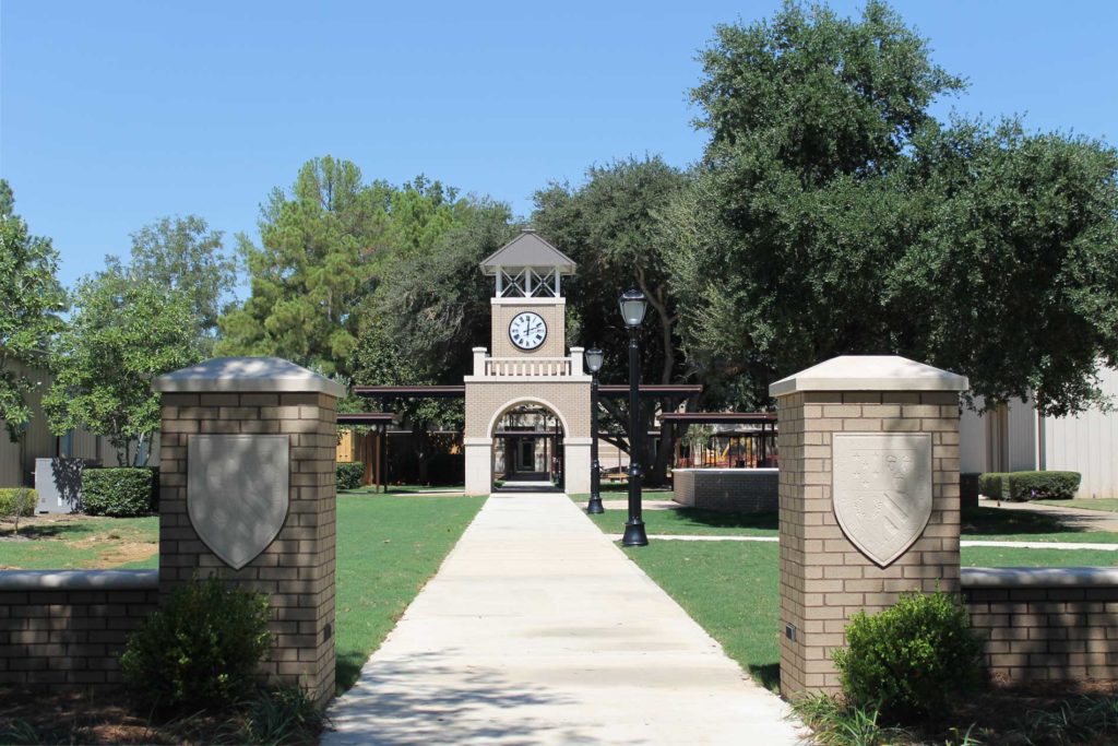 Brick entryway clock tower with a surface-mounted 48-inch illuminated Roman dial canister Tower Clock by Lumichron