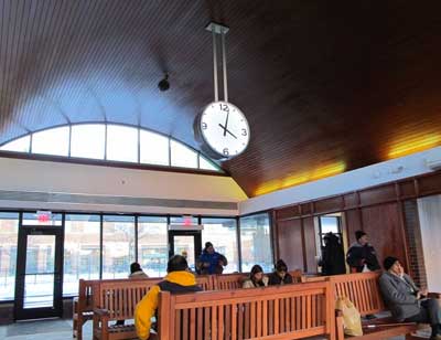 LUMICHRON clock hanging from ceiling at a bus station