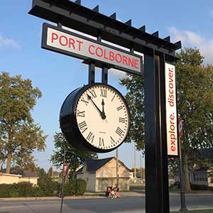 Bracket Clock mounted from above on sign that says "Port Colborne"