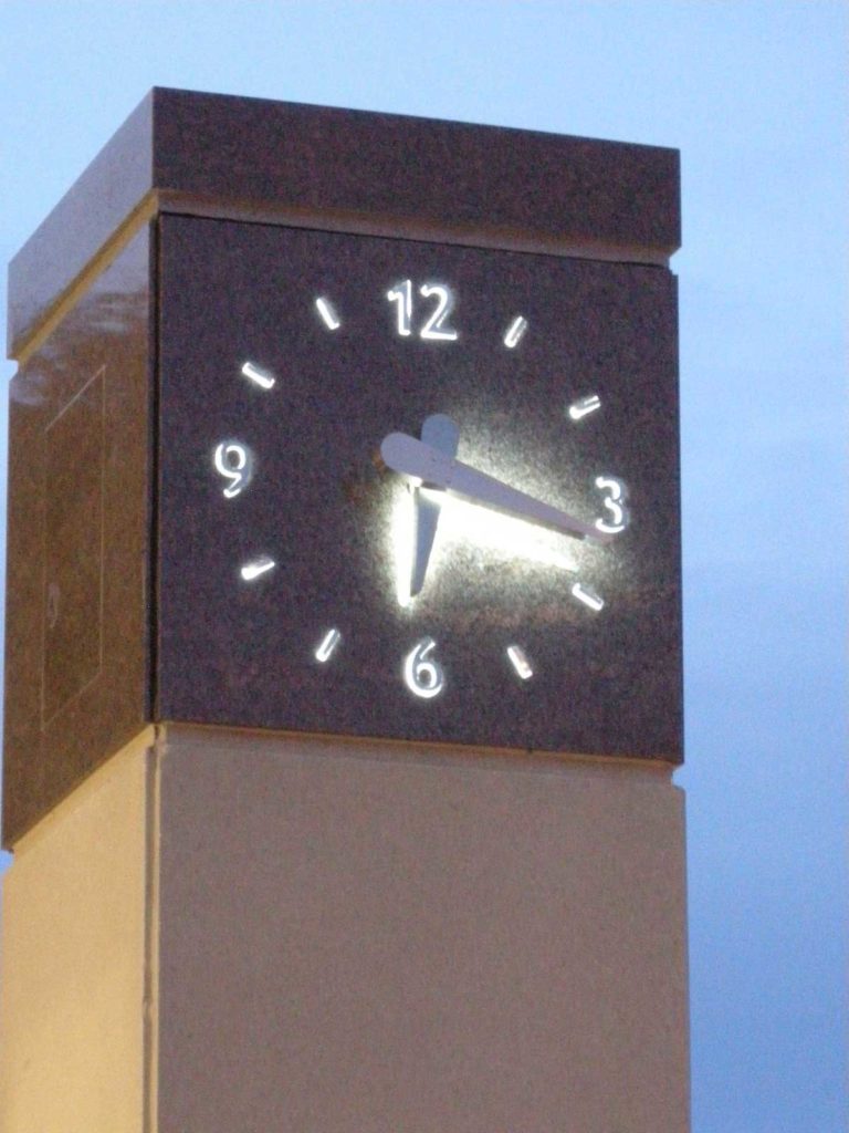 Close-up of the granite clock tower at Granger Hall University of Wisconsin with a Skeletal silhouette marker illuminated stainless steel clock by Lumichron