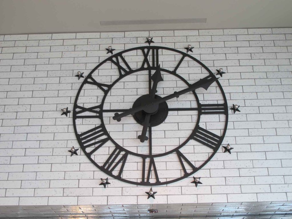 Custom Skeletal Roman dial clock on white brick with 12 decorative chrome ball and black star indexes by Lumichron