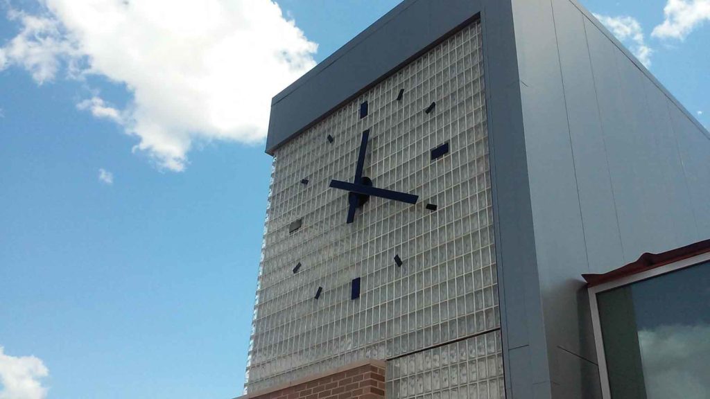 Skeletal silhouette marker 144-inch clock installed on glass block at WIU Riverfront campus building by Lumichron