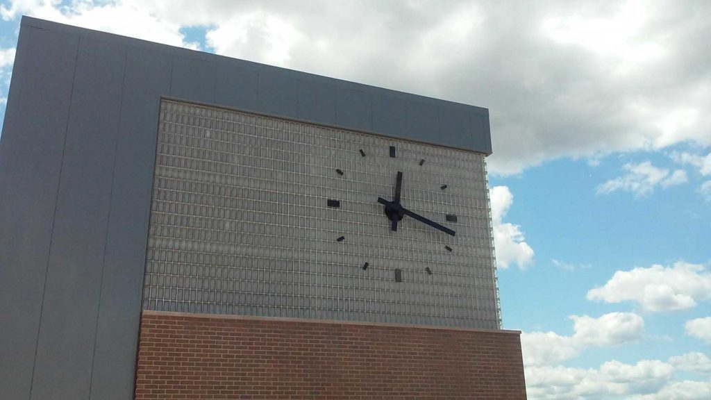 WIU Skeletal Silhouette marker automatic GPS Clock Tower Clock installed on glass block, quad city riverfront campus building, By Lumichron