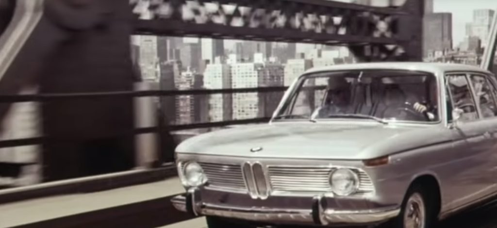black and white photo of a Vintage BMW car crossing a bridge in New York City