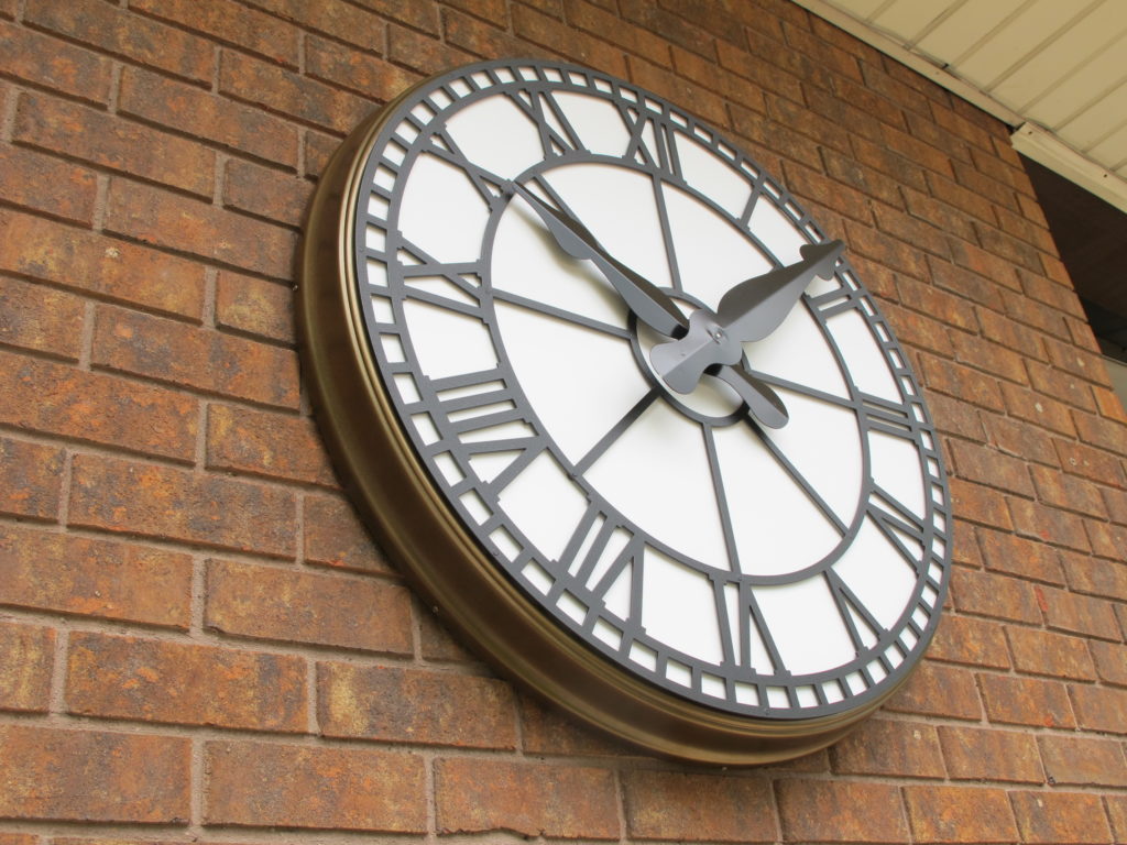 outdoor clock for a pool, recreation department or country club., roman dial clock on a brick wall 