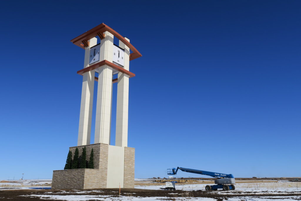 A view of the new Aurora Highlands 110' high tower clock. Tower clock design (including dial and hands) by EV Studio, and built by Lumichron.
