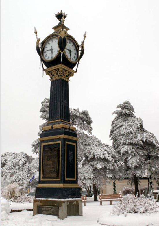 This is a Street Clock in the snow, in the city of DeKalb Illinois.  2021 is the centennial for the Soldiers and Sailors WWI Veterans Tribute -Memorial Clock