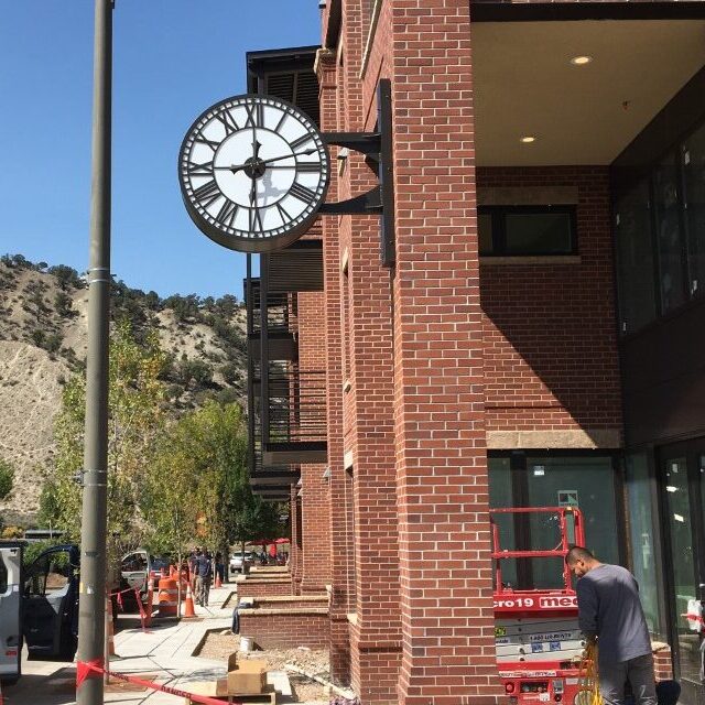 bracket clock on a building  with mountains in distance